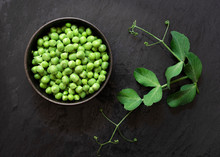 Shelled Green Peas In A Bowl With Leaves From The Plant.