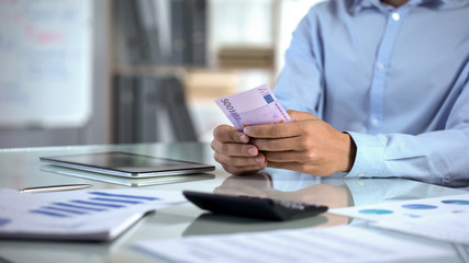 Wall Mural - Male accountant counting euro and planning company budget at office, banking