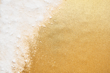 Wall Mural - white powdery snow on golden glitter background. snow and glitter for winter and christmas gift conc
