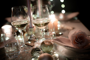 christmas eve party table with wine glass and glitter season's greeting decoration