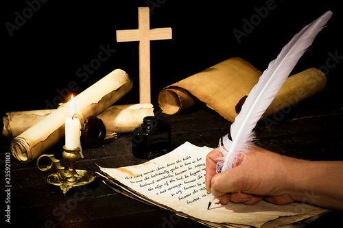 Fotografía A hand writing with a pen on the background of papyrus scrolls, against the back