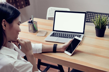 Fototapete - woman holding a blank screen phone and a laptop  and put a smart watch, film effect. Concept technology and modernization.