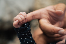 Close Up Of Newborn Baby Holding Onto Father's Finger
