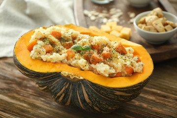 Canvas Print - Half of pumpkin with yummy risotto on wooden table