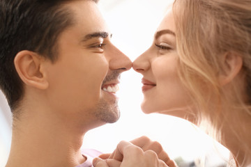 Wall Mural - Cute young couple dancing on light background