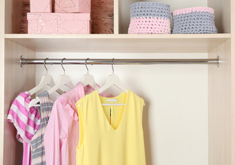 Poster - Stylish girl's clothes hanging in wardrobe, closeup