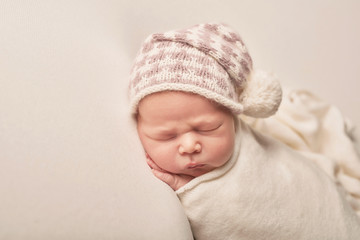 Cute newborn little boy sleeping on light background. Baby goods packaging template. Closeup portrait of newborn baby with smile on face. Healthy and medical concept. Eco conception. Nursery.