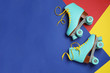 Pair of stylish quad roller skates on color background, top view with space for text