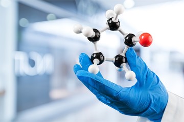Wall Mural - Close up of Molecular structure model in hand on background