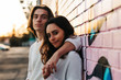 © ADDICTIVE STOCK - Portrait of young couple leaning on brick wall