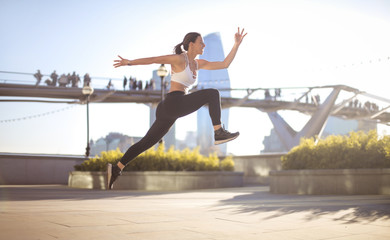 Sportive girl jumping high in the street