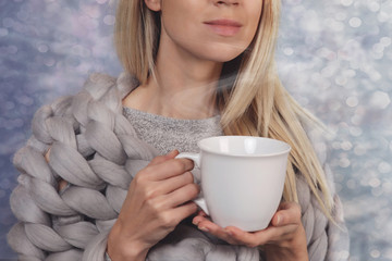 Wall Mural - Cozy woman wrapped in soft merino wool blanket , drinking coffee at home