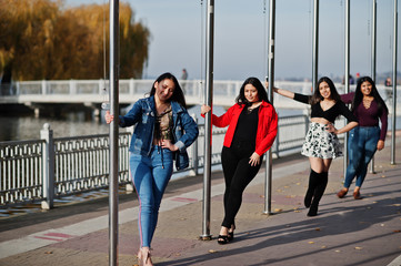 Wall Mural - Group of four happy and pretty latino girls from Ecuador posed at street.