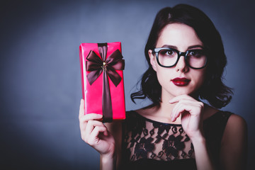 portrait of beautiful young woman holding gift on the wonderful grey studio background