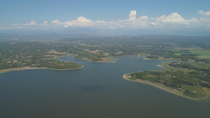 Aerial view of Paoay lake against background of mountains and sky with clouds. Paoay Lake National Park, Ilocos Norte, Philippines.