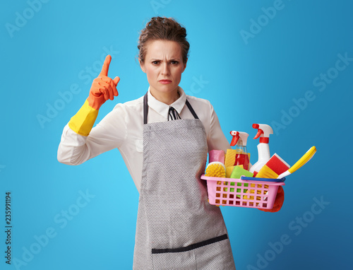 Fotografía scrubwoman with a basket with cleansers and brushes threatening