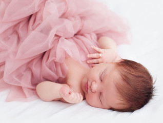 Wall Mural - newborn, two weeks old baby girl in ruffle dress and with finger ring is sleeping peacefully