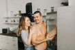 © Dmitriy Kapitonenko - beautiful couple in the kitchen take food out of the fridge
