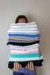 © September - Clean clothes from laundry in a stack in the hands of a housewife