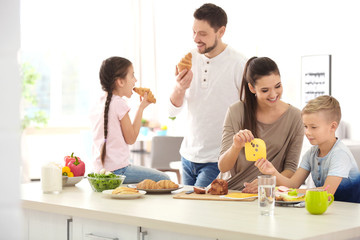 Canvas Print - Happy family having breakfast together in kitchen