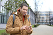 © Africa Studio - Young man in warm clothes using cell phone outdoors