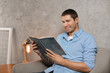 © Africa Studio - Young man in casual clothes reading book at home