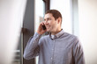 © Africa Studio - Young man in casual clothes talking on cell phone indoors