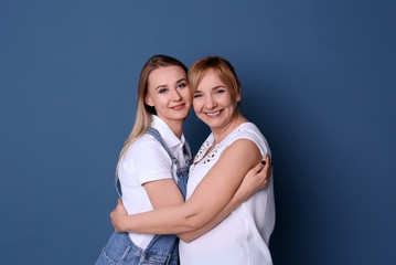 Canvas Print - Young woman with her mother on color background