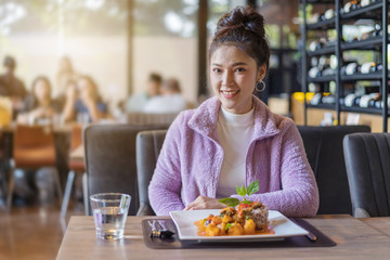 beautiful young woman with food in restaurant