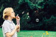 © Voyagerix - Man blowing soap bubbles outdoor