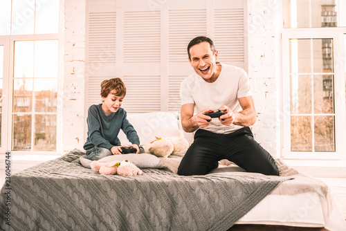 Fotografie, Obraz Father and son immersed in playing an interesting game.