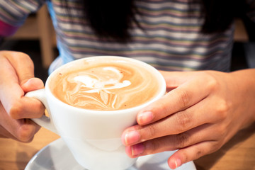 Hot coffee latte on a wooden table.