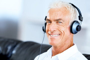 Wall Mural - Handsome gray haired senior man with headphones