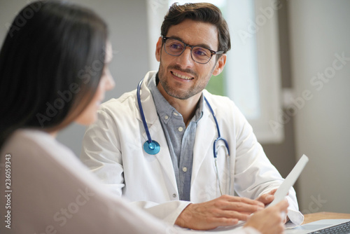 Fotografía Modern young doctor speaking to patient in office