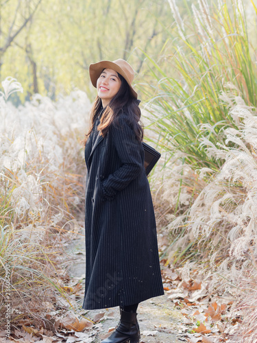 Photographie Beautiful young brunette woman in black coat and hat looking and smiling