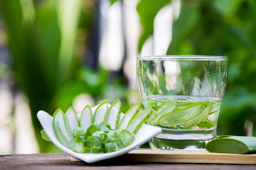 Wall Mural - Fresh aloe vera leaves and aloe vera juice on wooden floor, health concept