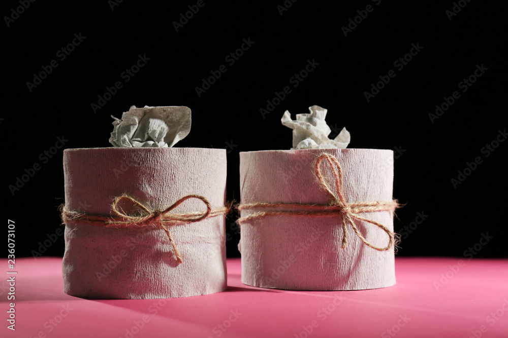 Creative soft toilet paper on color table against dark background