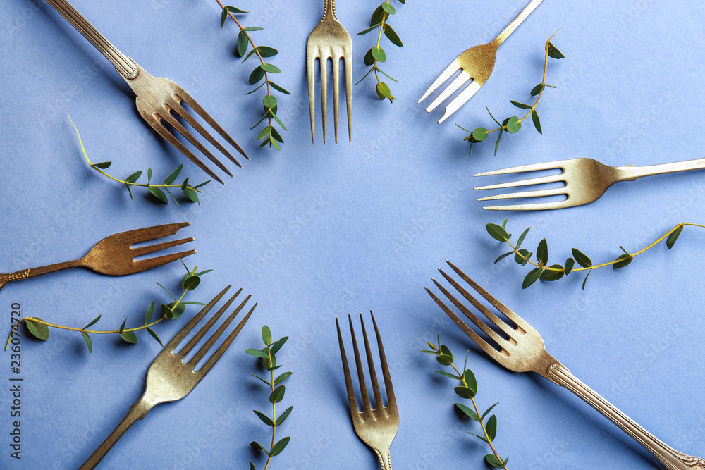 Set of forks on color background