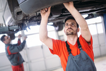 Wall Mural - Car mechanics working at automotive service center