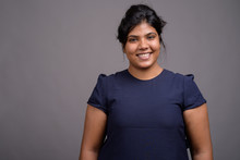 Young Overweight Beautiful Indian Woman Against Gray Background