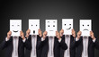 © asiandelight - five businessman holding a card with drawing facial expressions different emotion feelings face on white paper
