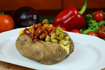 Wall Mural - Kumpir - Traditional Turkish meal with baked potato, butter, cheese, cucumber, chicken with barbecue sauce, and hot spices