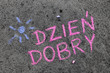 Kolorowy napis wykonany kredą na chodniku: słowo Dzień Dobry