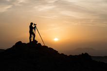 Silhouette Of Male Landscape Photographer Shooting With A Tripod