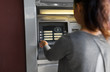 © Syda Productions - finance, cryptocurrency and technology concept - close up of woman at atm machine with bitcoin icon on screen
