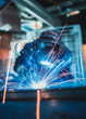A vibrant action shot of a skilled working metal welder in action, welding metal. Photographed with a slow shutter speed and spark trails. Orange and teal fashionable colour palette.