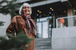 © Yakobchuk Olena - Waist up portrait of charming old lady in coat looking at camera and smiling. Copy space in right side
