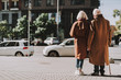 © Yakobchuk Olena - Back view full length portrait of old gentleman with cane and his wife standing on sidewalk. They wearing coats