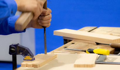 Carpenter with chisel and hammer in workshop