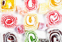 Candy Background. Colored Candy Wrapped In A Roll And Sprinkled With Coconut Flake. Turkish Delight.